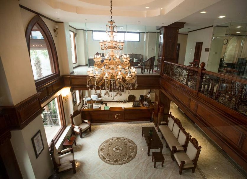 Capitol Residence in Vientiane lobby with grand chandelier, mezzanine railing, and seating area