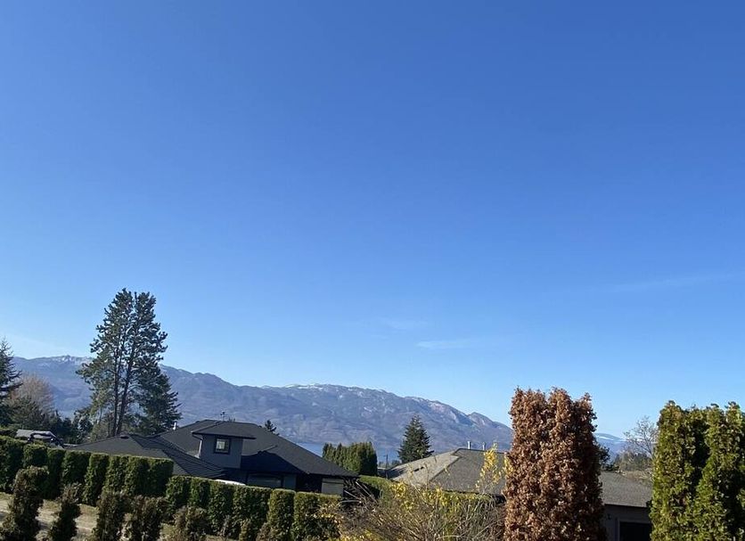 Beautiful Rodee Homestay West Kelowna with mountain views under a clear blue sky