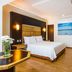 GH Galeria in Guayaquil guest room with queen bed, wood flooring, desk, and ocean artwork