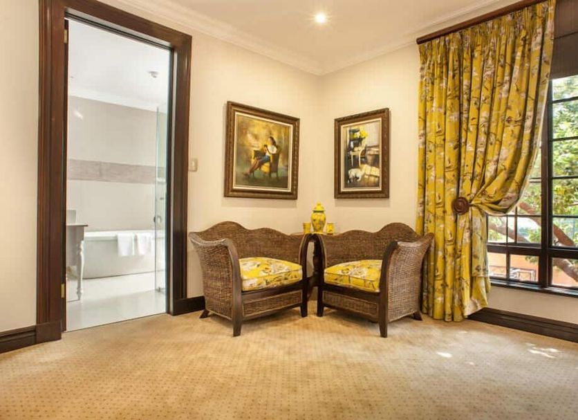 Ivory Manor Boutique Hotel in Pretoria: elegant suite seating area with wicker chairs and garden-view window