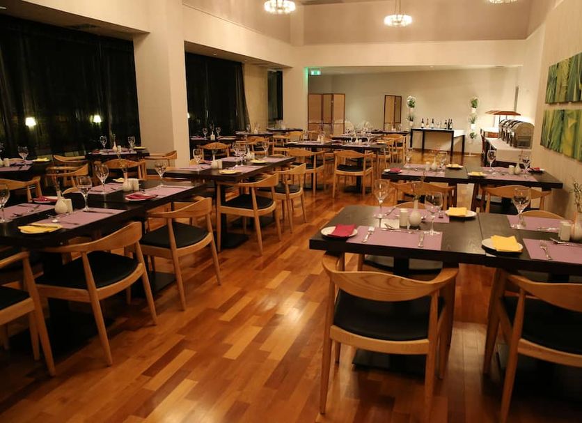 Altius Boutique Hotel Nicosia dining room with set tables and wooden chairs