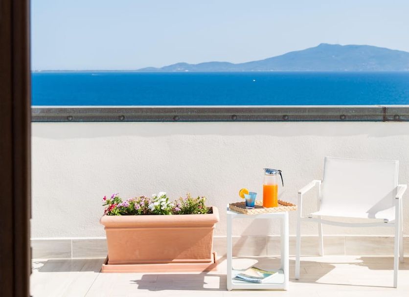 Balcony at Il Telamonio in Talamone with sea and mountain views, potted flowers, table and chair