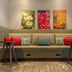 Hampton Inn Santa Clarita-Valencia lobby seating with colorful floral wall art and red accent pillows