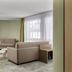 flexymotel Buchs lounge with sofa, chairs, side table and large window in Buchs