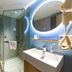 Home Inn Neo Lanzhou City Museum Dongfanghong Plaza Wanxiang City bathroom with glass shower, sink and lit mirror