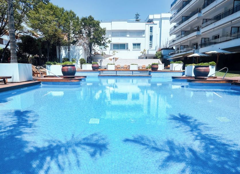 Suites del Mar Fenals in Lloret de Mar: outdoor pool with sun loungers and hotel building