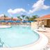 Berkley Lake Townhomes in Kissimmee with a resort-style outdoor pool and palm trees