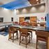 Holiday Inn Express & Suites Minneapolis Golden Valley breakfast area with bar seating and dining tables