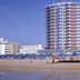 Hotel Caravelle, Jesolo: beachfront high-rise tower behind a sandy beach with umbrellas and loungers