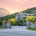 Shotover Lodge in Queenstown at sunset with mountain backdrop and stone gate entrance
