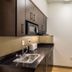 Studio 6 Mcallen Tx kitchenette with sink, microwave, cabinets, and mini fridge in McAllen
