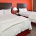La Bonita Inn & Suites - Mccamey guest room with two beds, nightstand, and window in McCamey