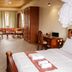 Hotel Duomo And Suites in Kampala: bedroom with wooden bed, desk, wardrobe, and dining area