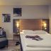 Fürther Hotel Mercure Nürnberg West guest room with double bed, armchair and floor lamp in Fürth