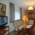 Pension Waldesruh in Görgeshausen sitting room with floral sofa, armchair, lamp and display cabinet