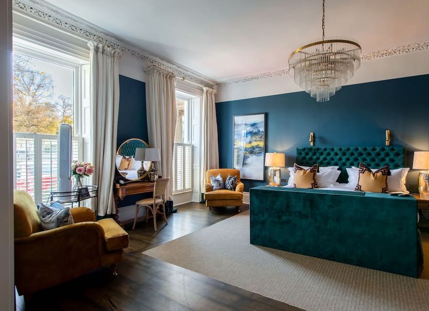 No38 The Park in Cheltenham: elegant guest room with teal velvet bed and large windows