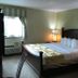 Marvin's Garden Inn in Southfield guest room with king bed, bedside lamps and window air conditioner