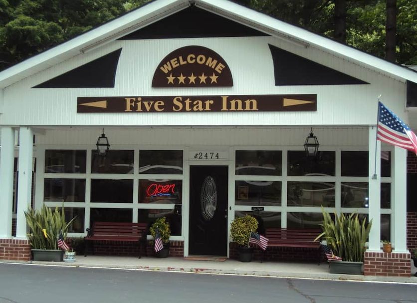 Five Star Inn in Maggie Valley storefront with U.S. flag, benches, and entrance