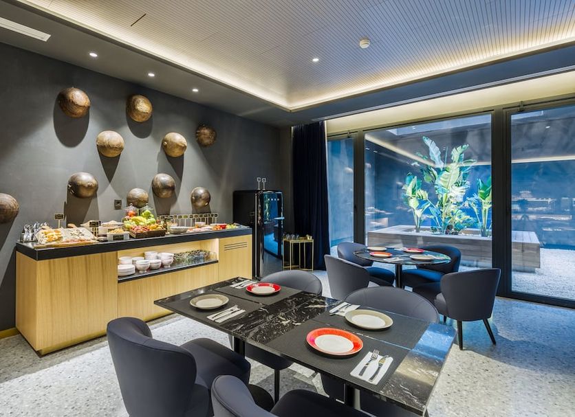 Room Mate Collection Gerard, Barcelona breakfast room with buffet and table by large windows