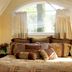 Bella Vista Bed and Breakfast in Placerville, cozy bed beneath arched window with sheer curtains