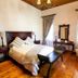 Old House Lodge in Beaufort West guest room with double bed, wooden floors, vanity and armchair
