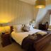 Ilsington Country House Hotel & Spa room in Newton Abbot with king bed, window seat and wooden furnishings