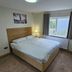Homefield Lodge London guest room with double bed, window, desk, and wall-mounted TV