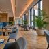 Mövenpick Hotel Basel dining room with large windows, blue banquette seating and potted plants