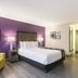La Quinta Inn & Suites by Wyndham Virginia Beach room with king bed and yellow armchair