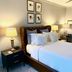 1842 Inn in Macon guest room with tufted leather headboard, white bedding, and bedside lamps