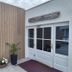 Doonmore Hotel in Inishbofin entrance with white double doors, wood siding, and potted plants