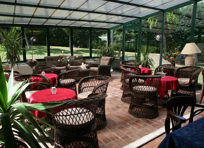Hotel Palacio De La Viñona in Oviedo: enclosed garden terrace with wicker seating and tables