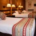 Hotel Raymi Cusco guest room with three neatly made single beds and warm bedside lamps