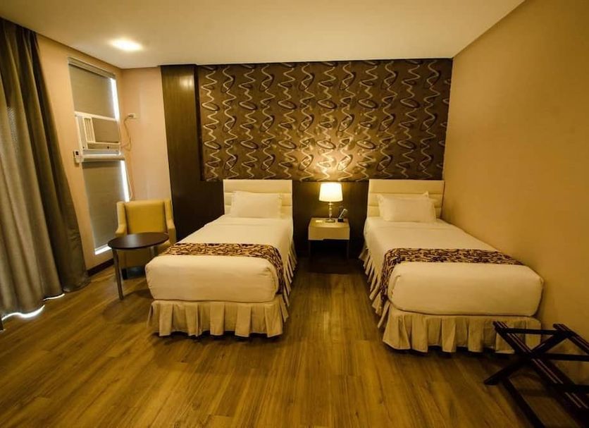 Oryza Hotel Santiago twin room with two single beds, bedside lamp and wood flooring