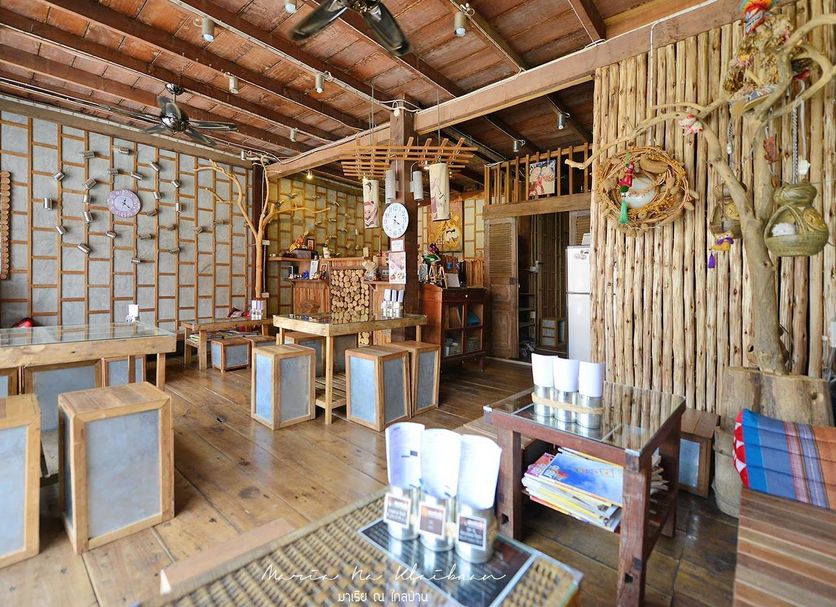 Songphuamia Guesthouse in Chiang Khan lobby with wooden tables, stools and bamboo decor