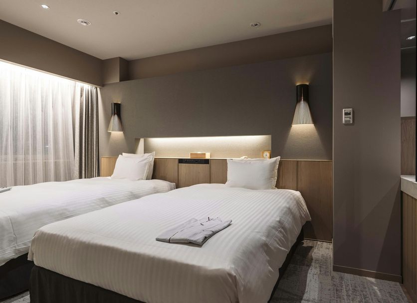 Richmond Hotel Obihiro Ekimae in Obihiro room with two twin beds and warm wall lighting