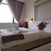 The Rass Kanpur guest room with king bed, window seat and large window view