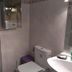 Pension Mari Asun bathroom with shower, toilet, sink, and wall mirror in Pamplona