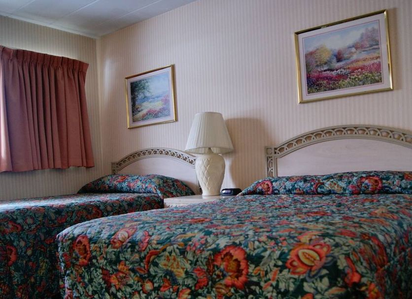 Meadow Court Inn in Ithaca room with two floral-covered beds and framed wall art