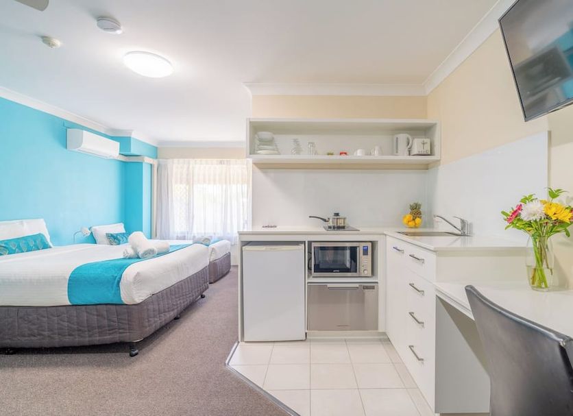 Byron Bayside Central Studio Apartments in Byron Bay with twin beds, kitchenette, desk, and wall-mounted TV