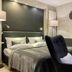 Country-Suites By Verdino Living - Apartments & Privatzimmer in Braunlage, a bedroom with bed and black lounge chairs.