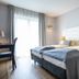 Hotel Rheinischer Hof Bad Soden guest room with two beds, tufted headboards, and large window