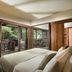 Adiwana Resort Jembawan, Ubud bedroom with bed and sliding glass doors to a leafy balcony