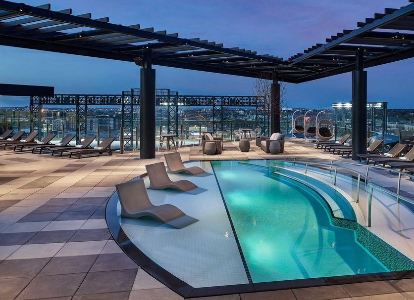 The Rally Hotel at McGregor Square in Denver rooftop pool with lounge chairs and city views