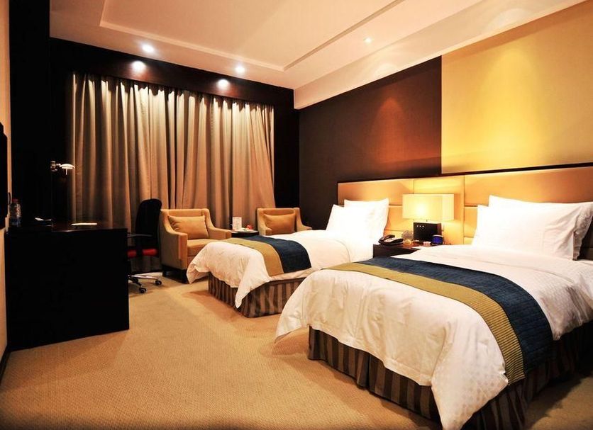 Haobo International Hotel in Wuxi guest room with two twin beds and warm lighting