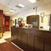 Sun City Hotel Tel Aviv reception desk with mirror, wood paneling, and floral arrangement