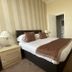 Alexander's in Hastings guest room with double bed, bedside lamps and striped walls