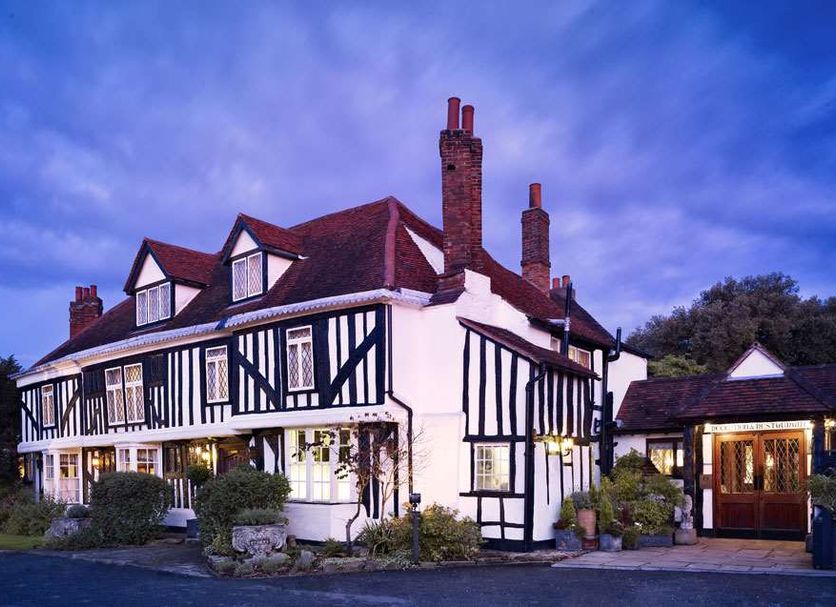Marygreen Manor Hotel in Brentwood, Tudor-style exterior at dusk with lit windows and landscaped entrance
