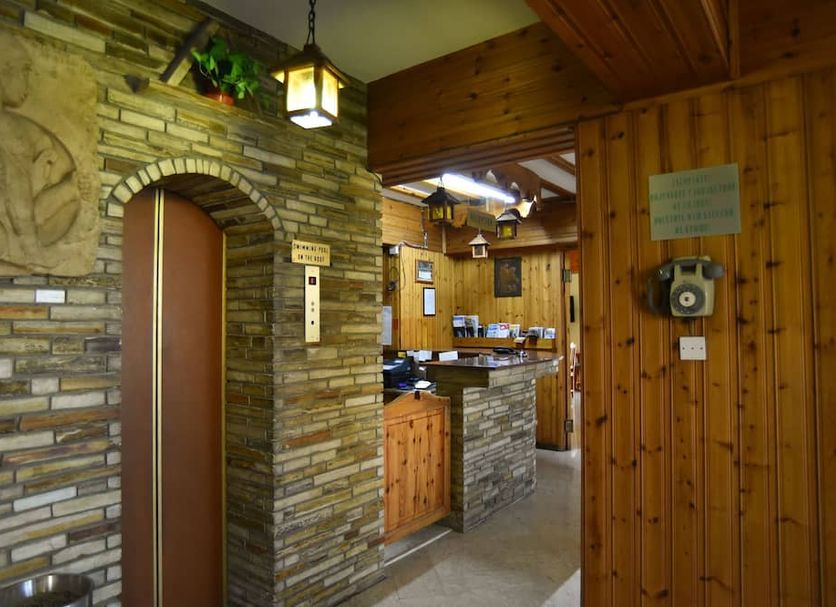 Elysso Hotel in Larnaca reception area with stone archway and wood-paneled front desk