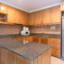 Jomtien Beach Residence in Pattaya kitchen with wood cabinets, granite counter and breakfast bar